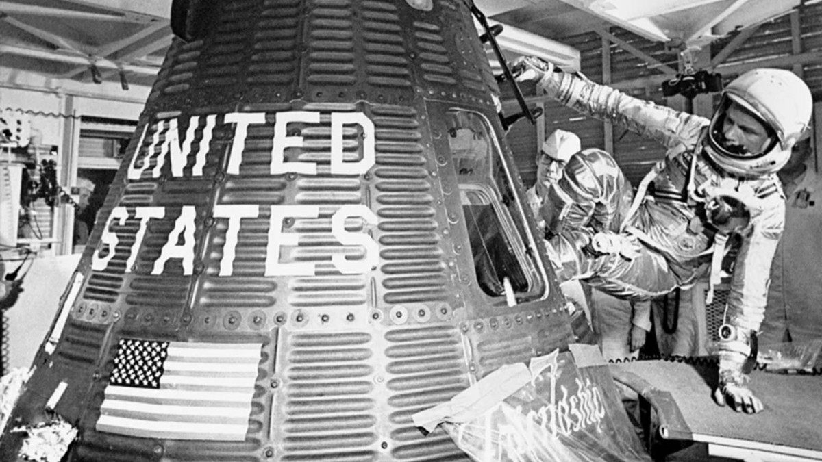 John Glenn climbs into a spacecraft.